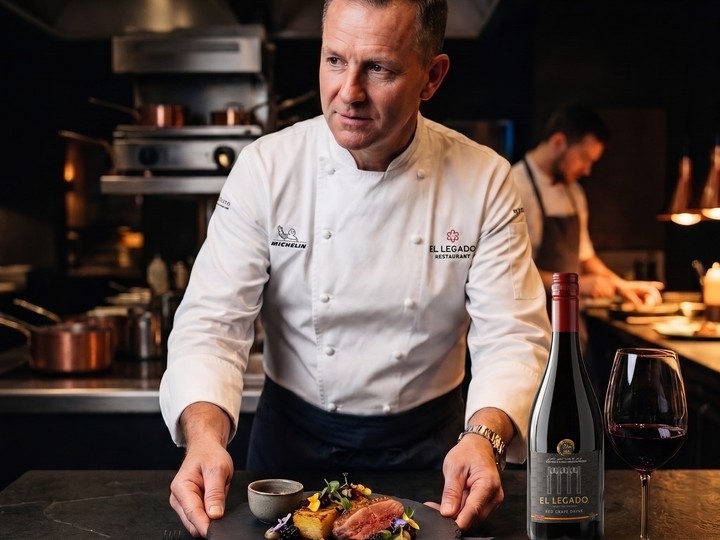Chef emplatando junto a una botella de El Legado Red Grape Drink